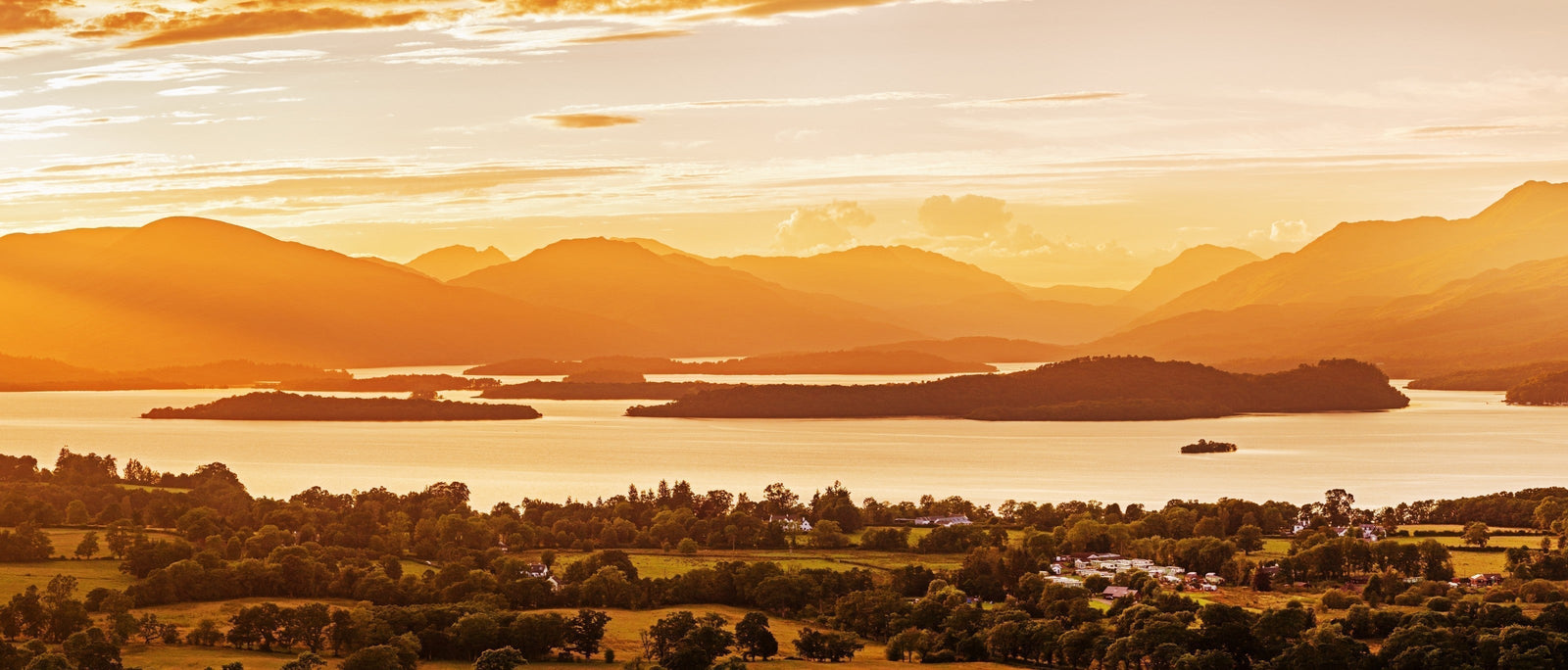 Golden panoramic view of Loch Lomond (the largest inland stretch of water in Great Britain) at sunset.