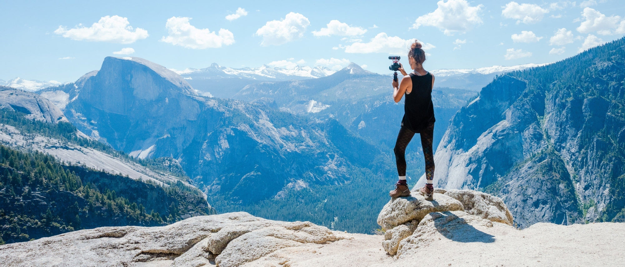 Vlogger capturing a mountain panorama in Yosemite, California, USA.