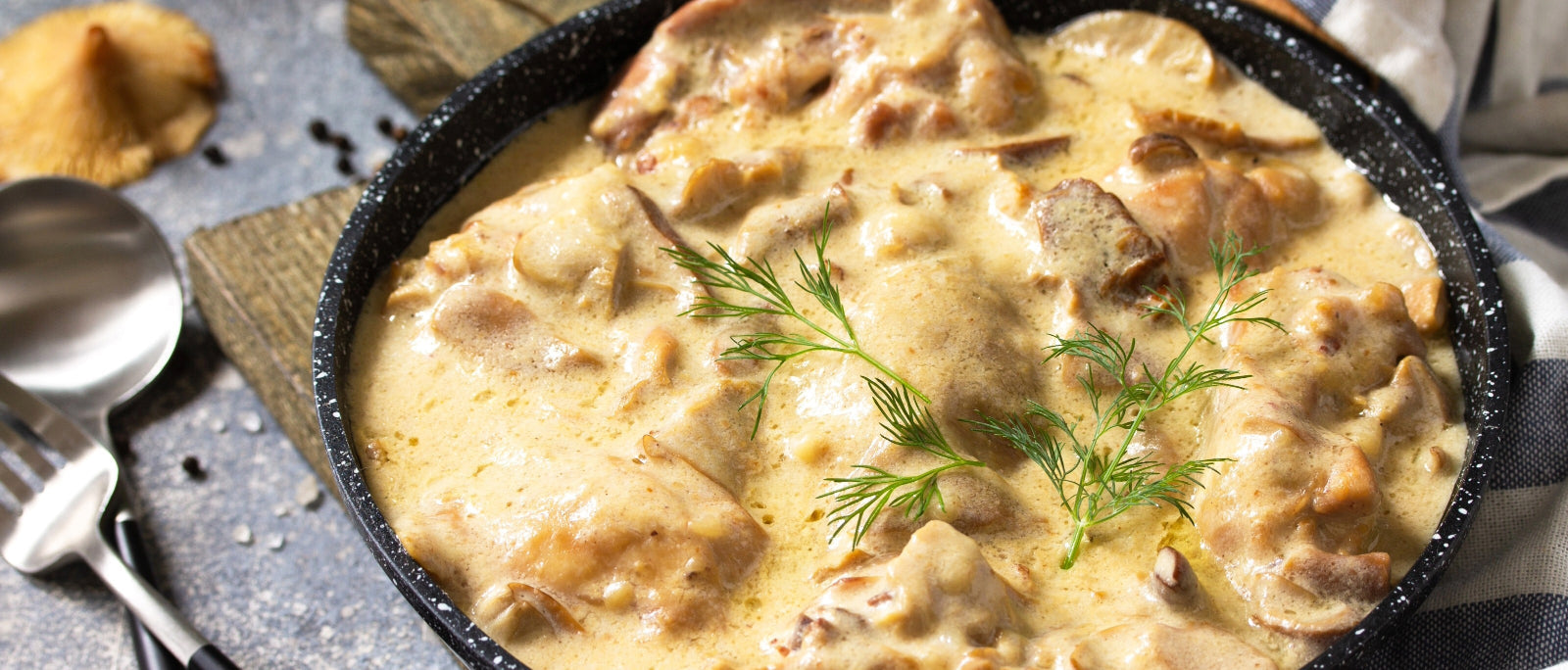 a black bowl full of creamy soup on a granite counter top